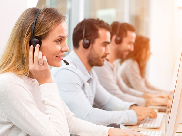 A group of customer service employees on the phone with customers